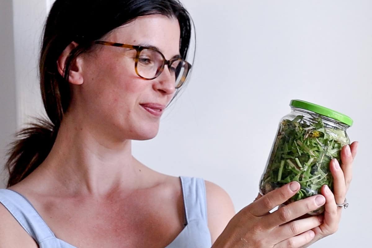 holding dandelion tincture in a jar