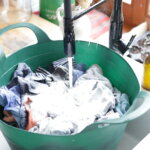green plastic tub filled with clothing