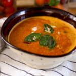 tomato soup in a bowl with basil on top