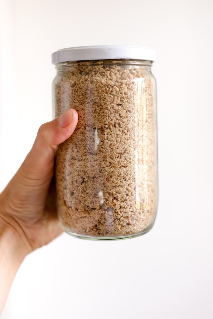 holding a jar of sourdough crumbs
