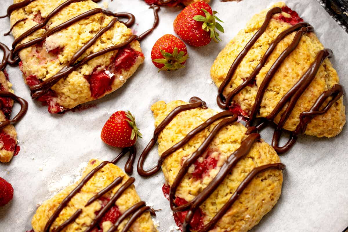 Golden baked strawberry scones with melted chocolate drizzle
